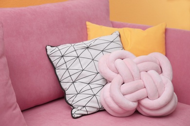 Photo of Different soft pillows on sofa, closeup. Interior element