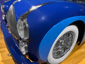 Photo of Beautiful blue retro car in salon, closeup view