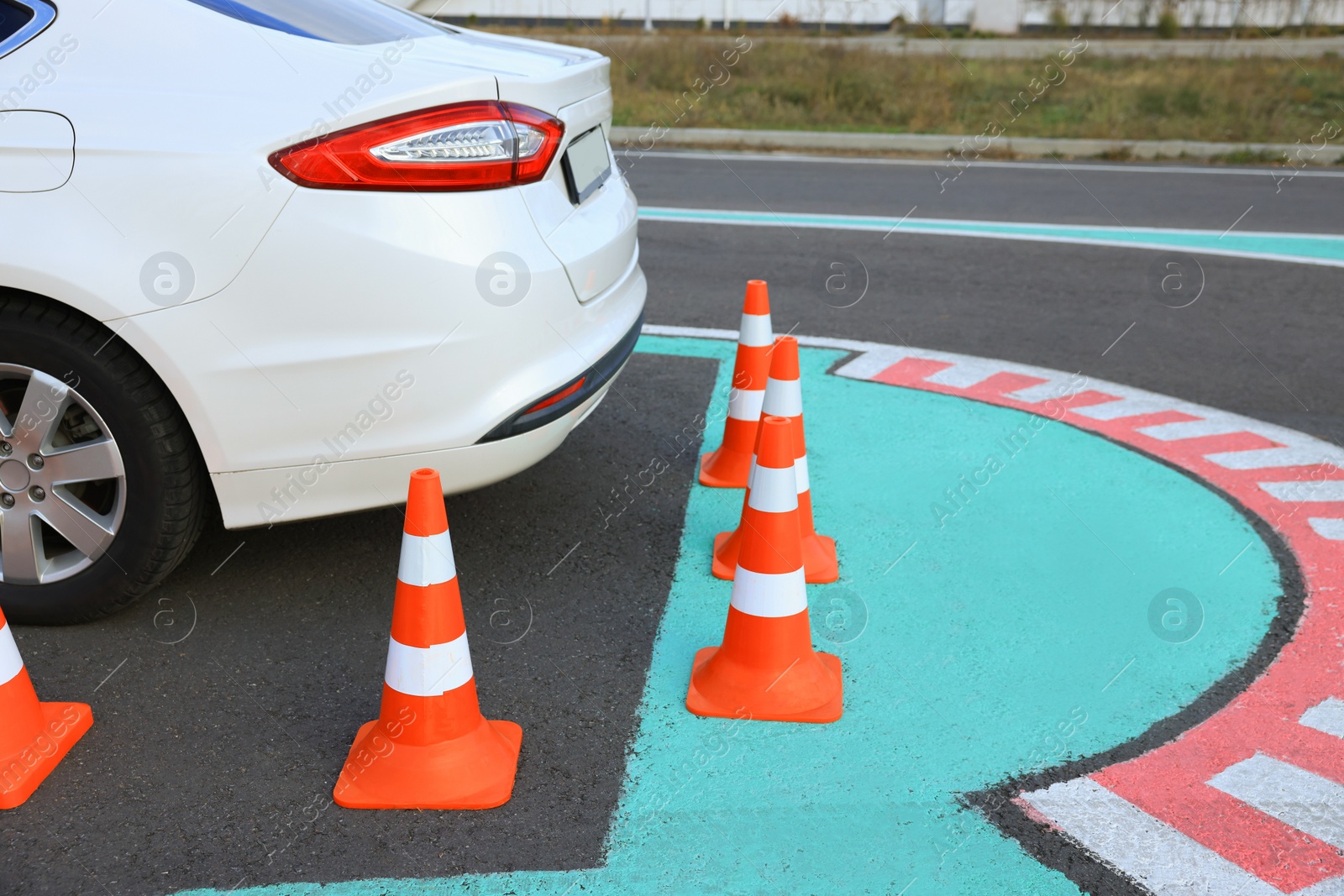 Photo of Modern car on driving school test track with traffic cones