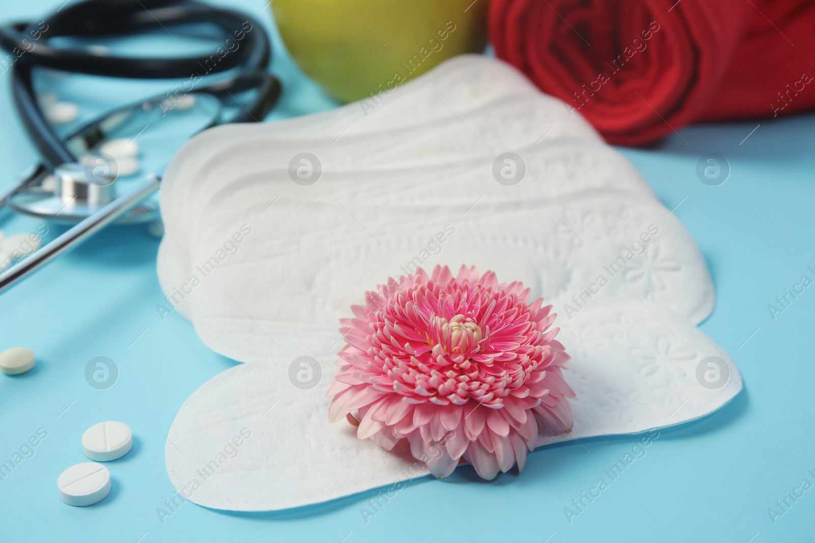 Photo of Composition with menstrual pads and flower on color background. Gynecological checkup