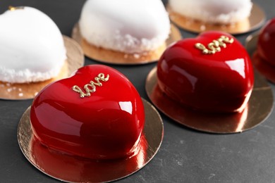 Photo of St. Valentine's Day. Delicious heart shaped cakes on black table, closeup