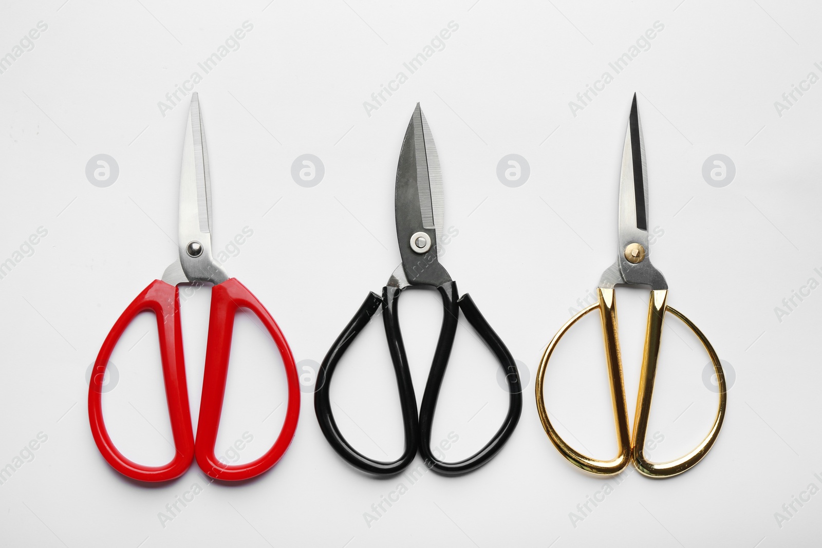 Photo of Set of different scissors on white background, top view