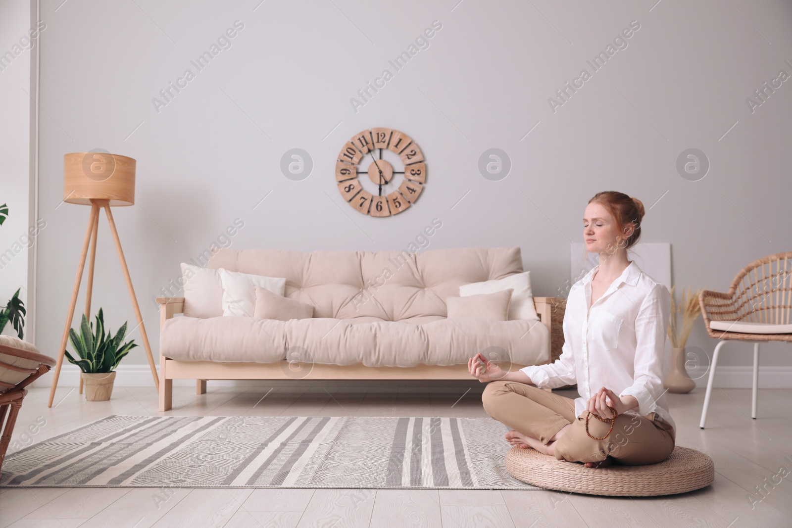 Photo of Woman meditating on wicker mat at home. Space for text