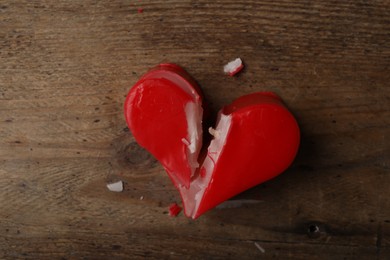 Photo of Broken heart shaped soap bar on wooden background, top view. Relationship problems concept