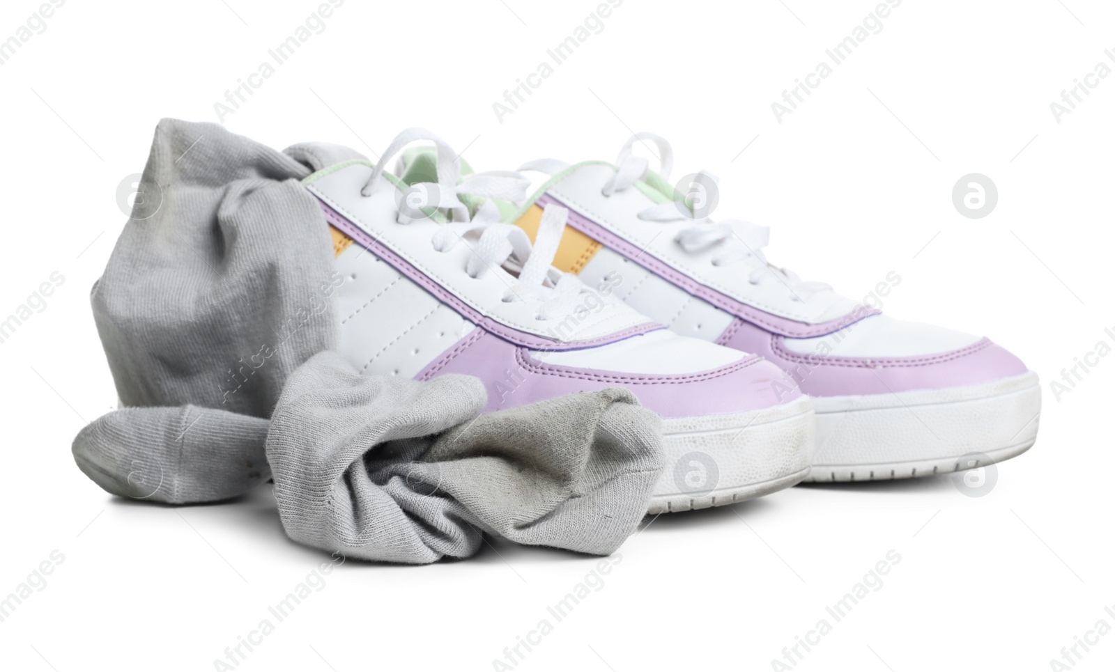 Photo of Dirty socks and sneakers on white background