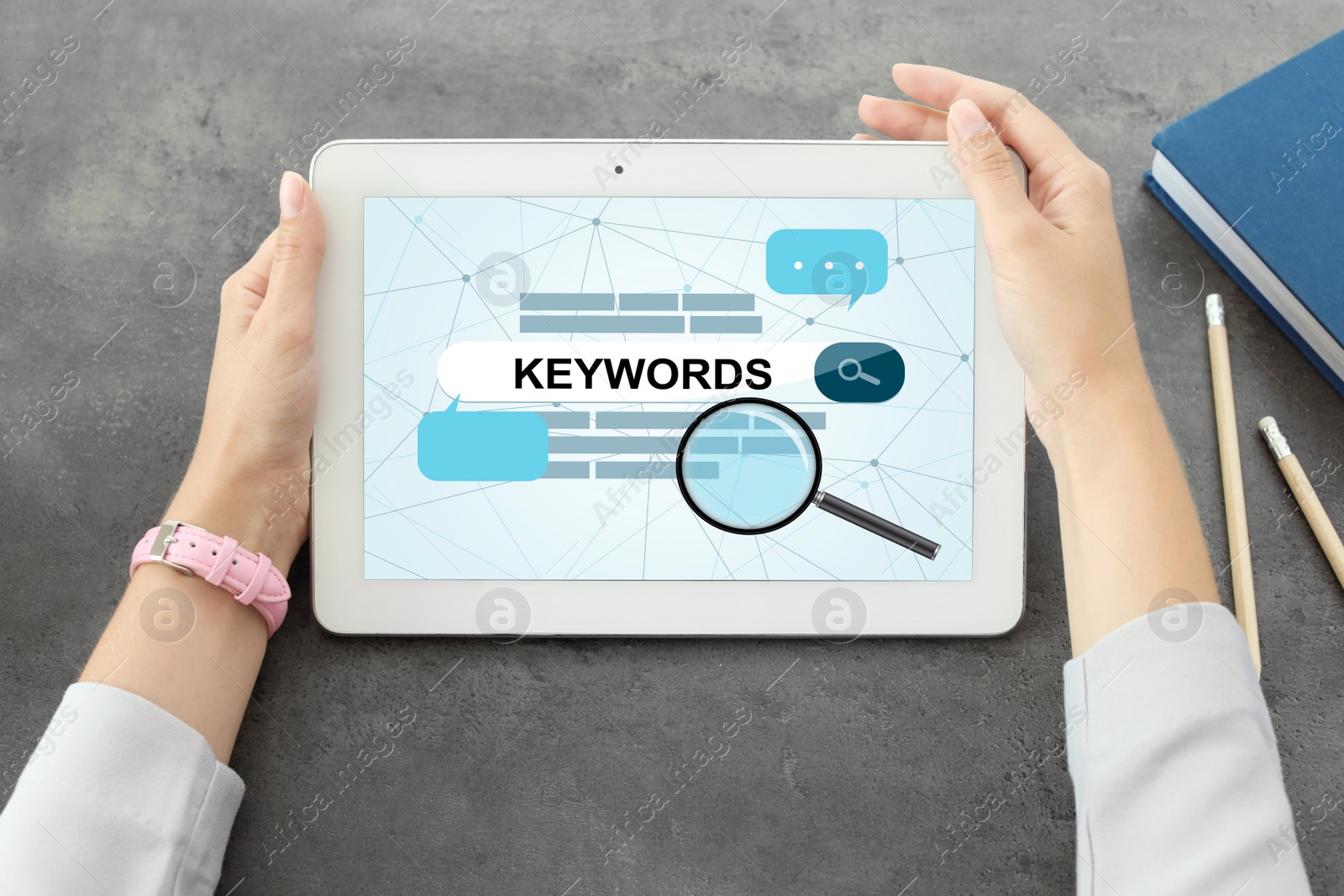 Image of Woman with tablet searching for keywords at grey table, closeup