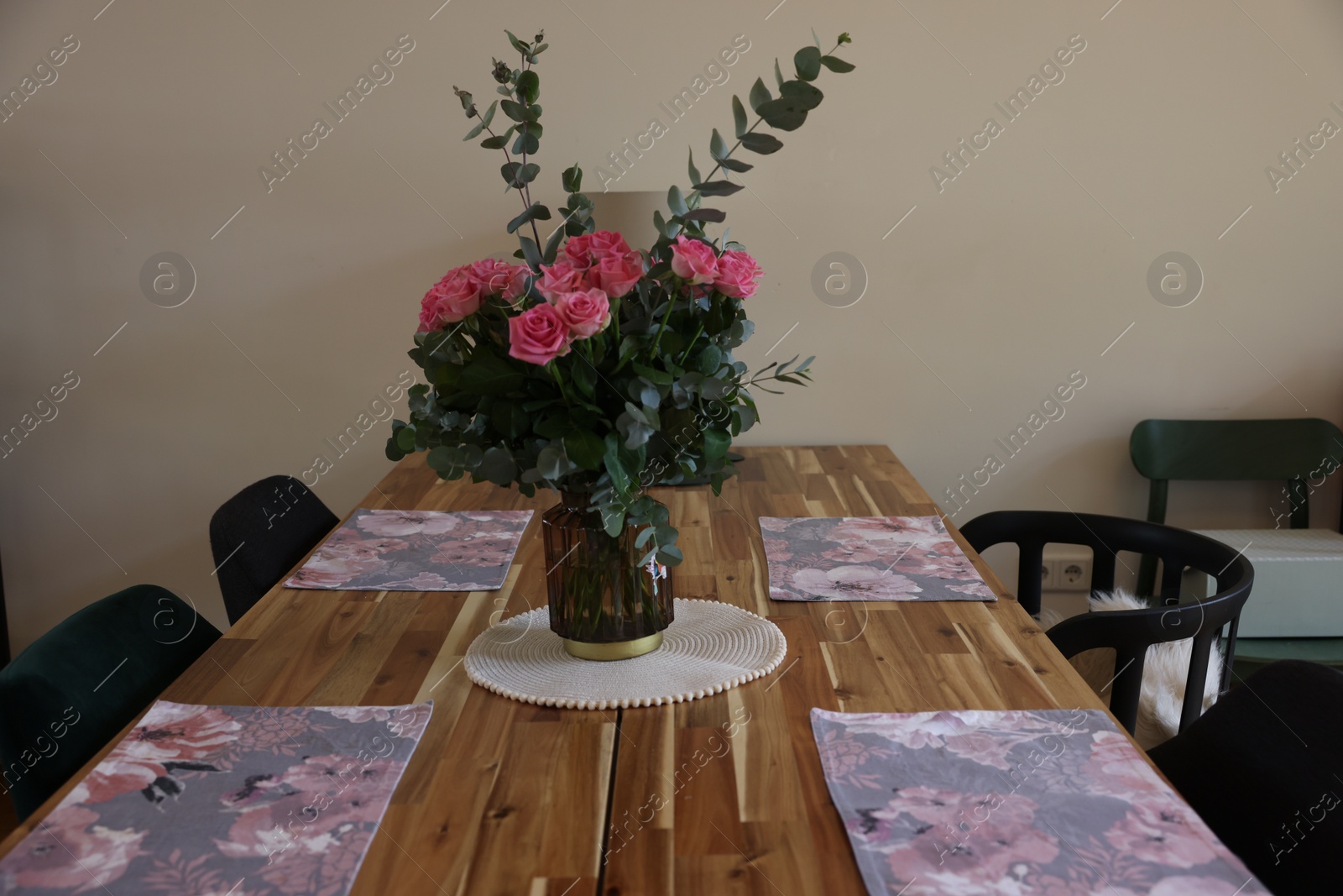 Photo of Beautiful bouquet of roses and napkins on wooden table indoors