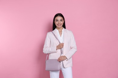 Photo of Beautiful young woman with stylish bag on pink background