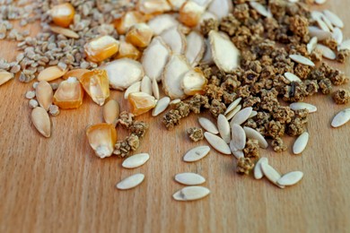 Photo of Different vegetable seeds on wooden table, closeup