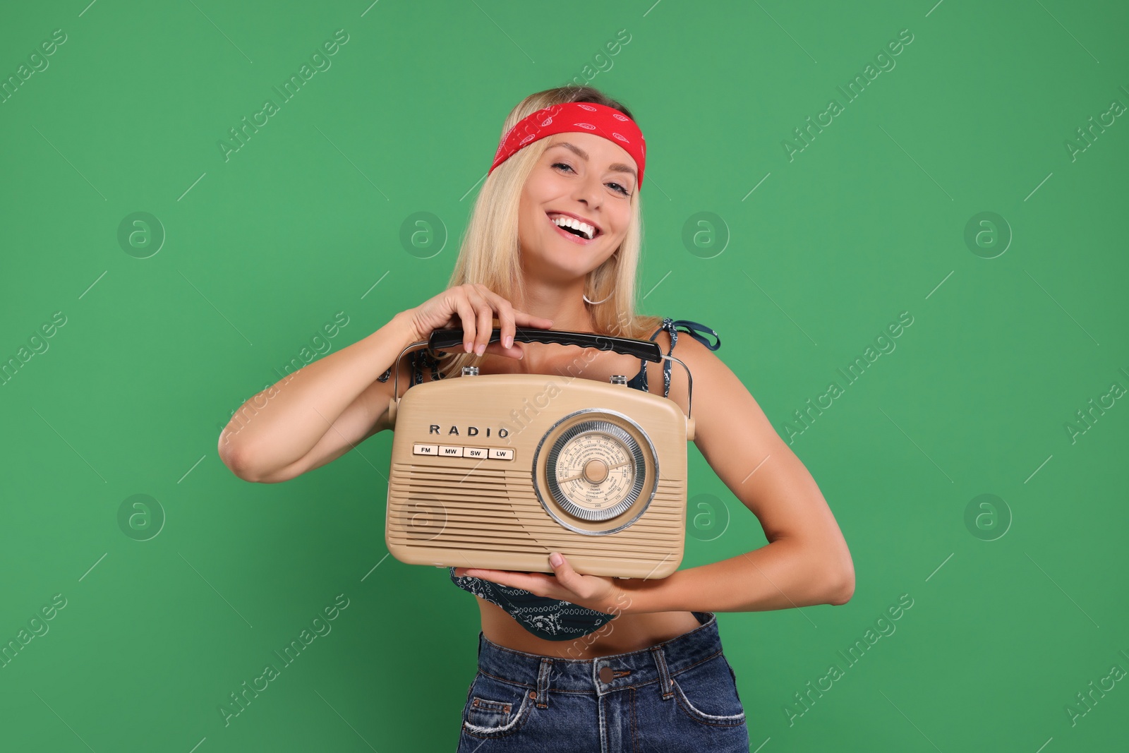 Photo of Happy hippie woman with retro radio receiver on green background