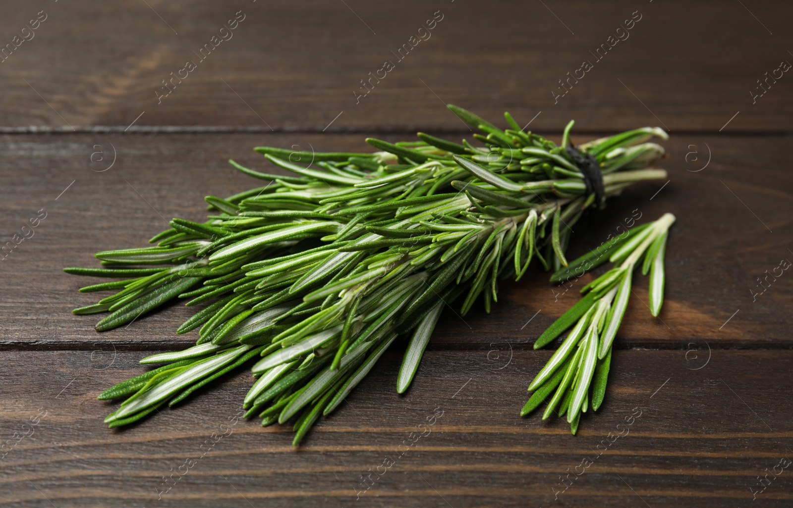 Photo of Bunch of fresh rosemary on wooden table