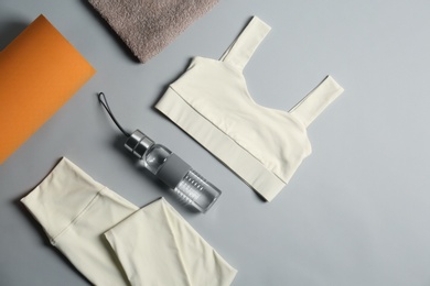 Photo of Flat lay composition with yoga equipment on grey background