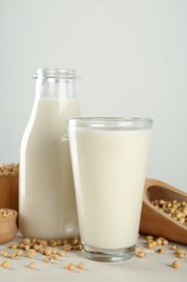 Photo of Fresh soy milk and grains on white wooden table