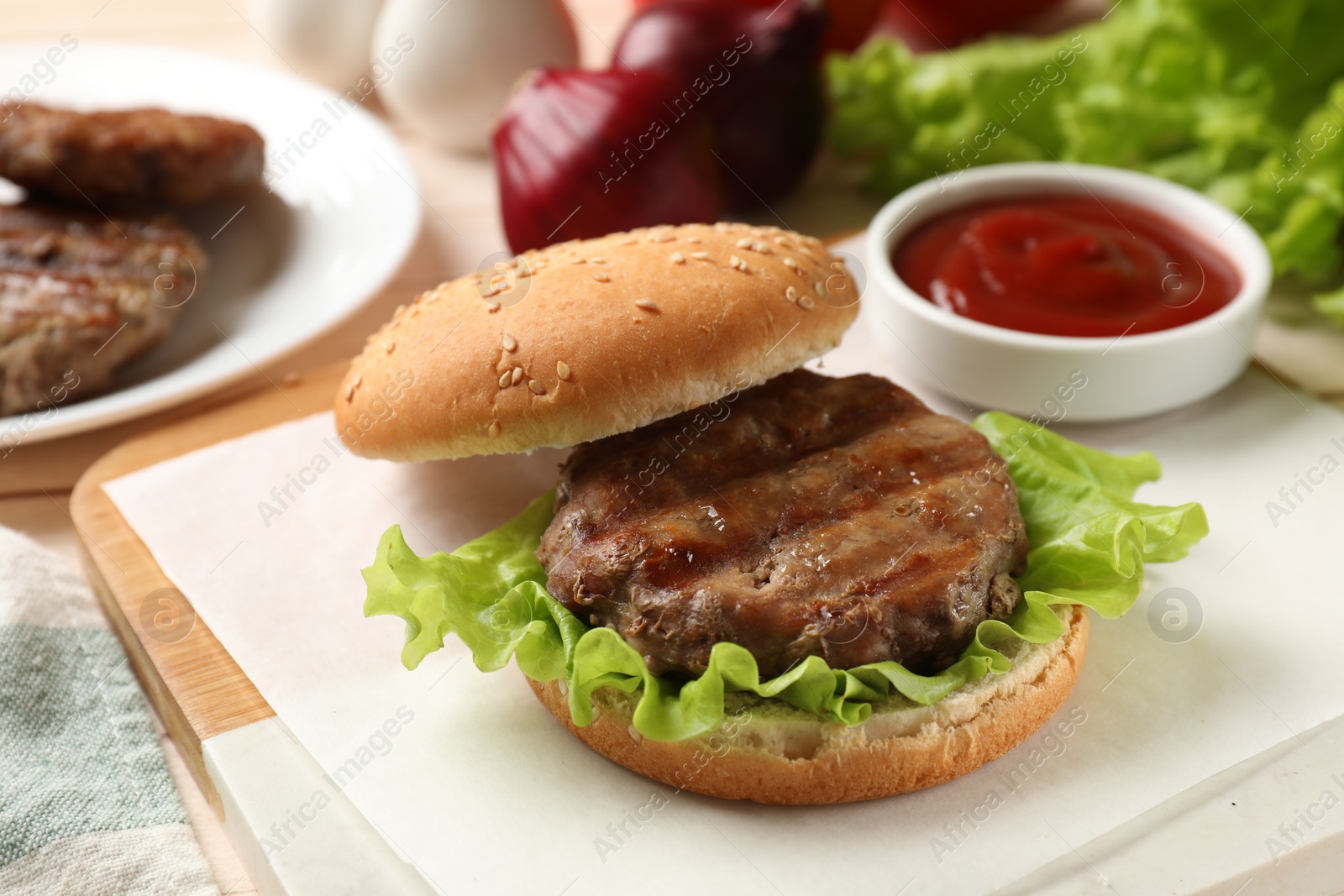 Photo of Delicious fried patty, lettuce, buns and sauce on table. Making hamburger