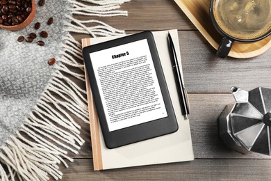 Image of Flat lay composition with portable e-book reader and notebook on wooden table