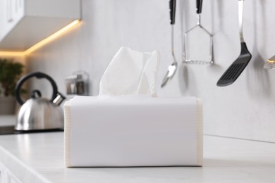 Package of paper towels on white countertop in kitchen