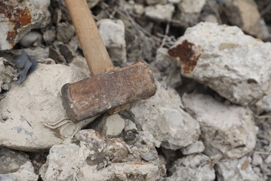 Photo of Sledgehammer on pile of broken stones outdoors, above view