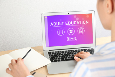 Woman using laptop for online studying indoors, closeup. Adult education 