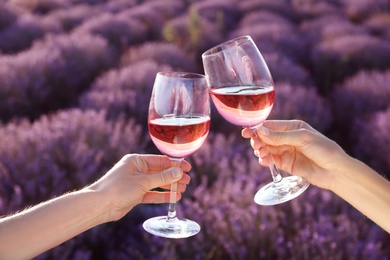 People with glasses of wine in lavender field