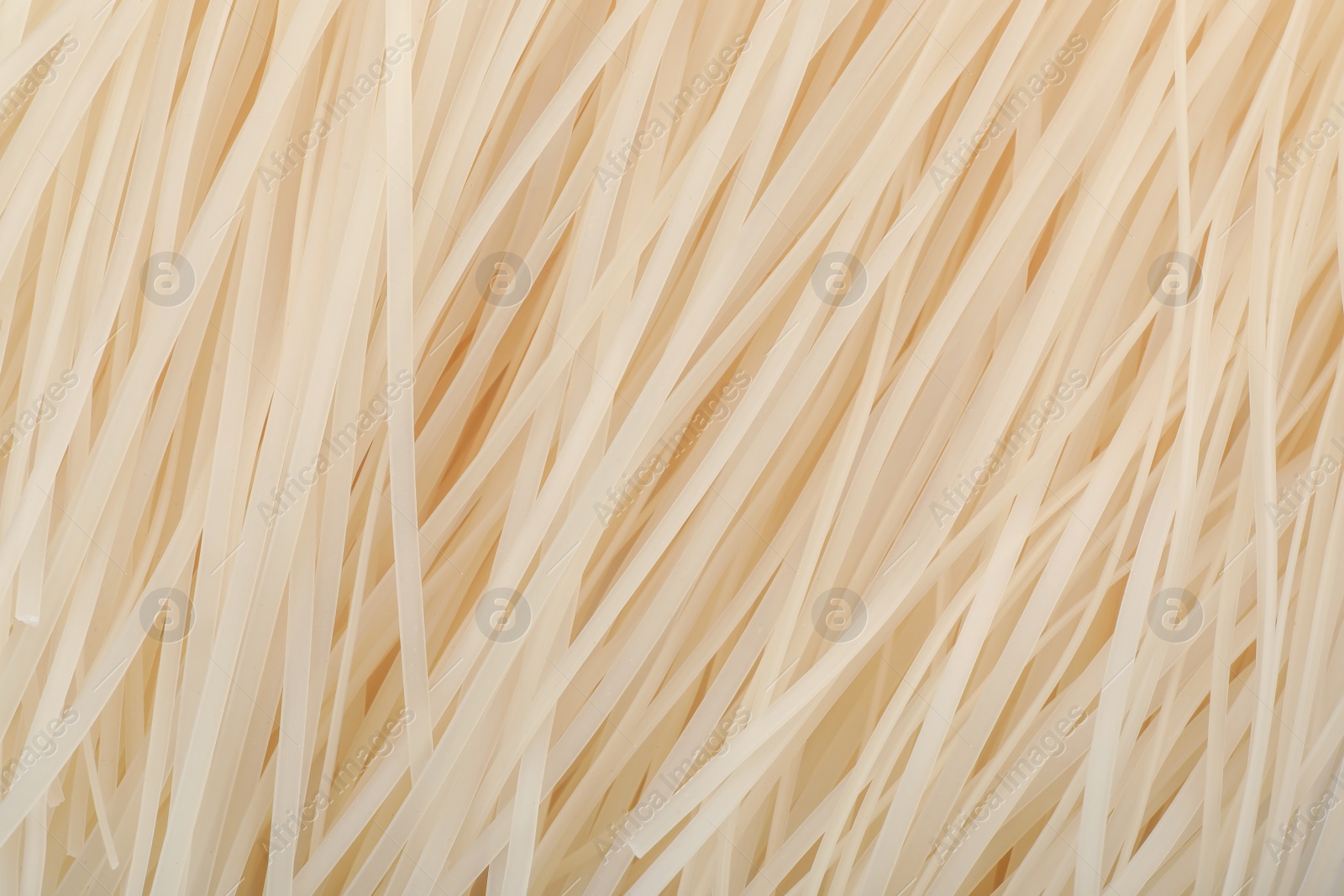 Photo of Raw rice noodles as background, closeup. Delicious pasta