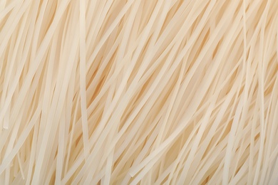 Photo of Raw rice noodles as background, closeup. Delicious pasta