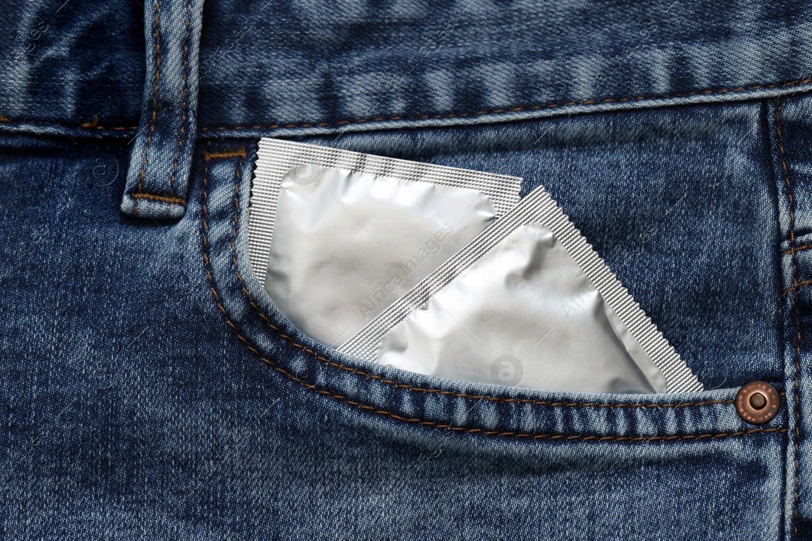 Photo of Packaged condoms in jeans pocket, closeup. Safe sex