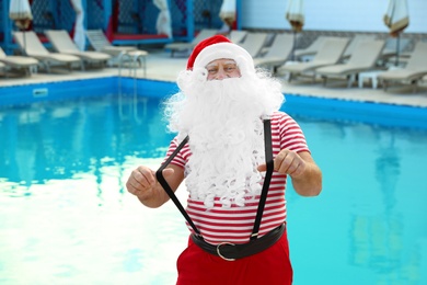 Authentic Santa Claus having fun near pool at resort