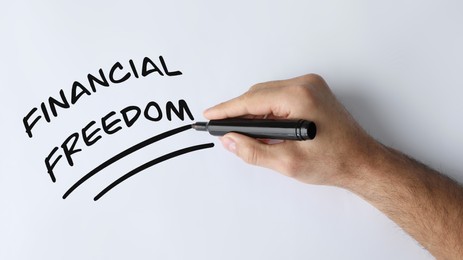 Image of Man underlining words Financial Freedom on white background, top view