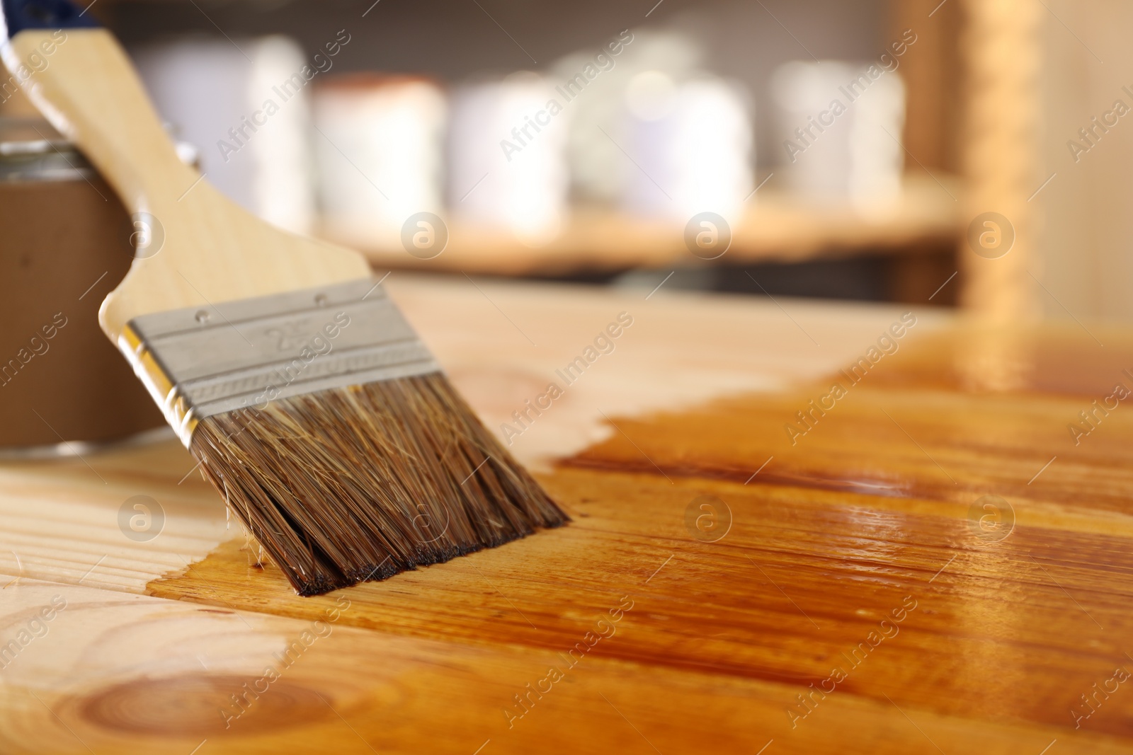 Photo of Brush and can with wood stain on wooden surface. Space for text