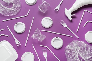 Different plastic items on purple background, flat lay