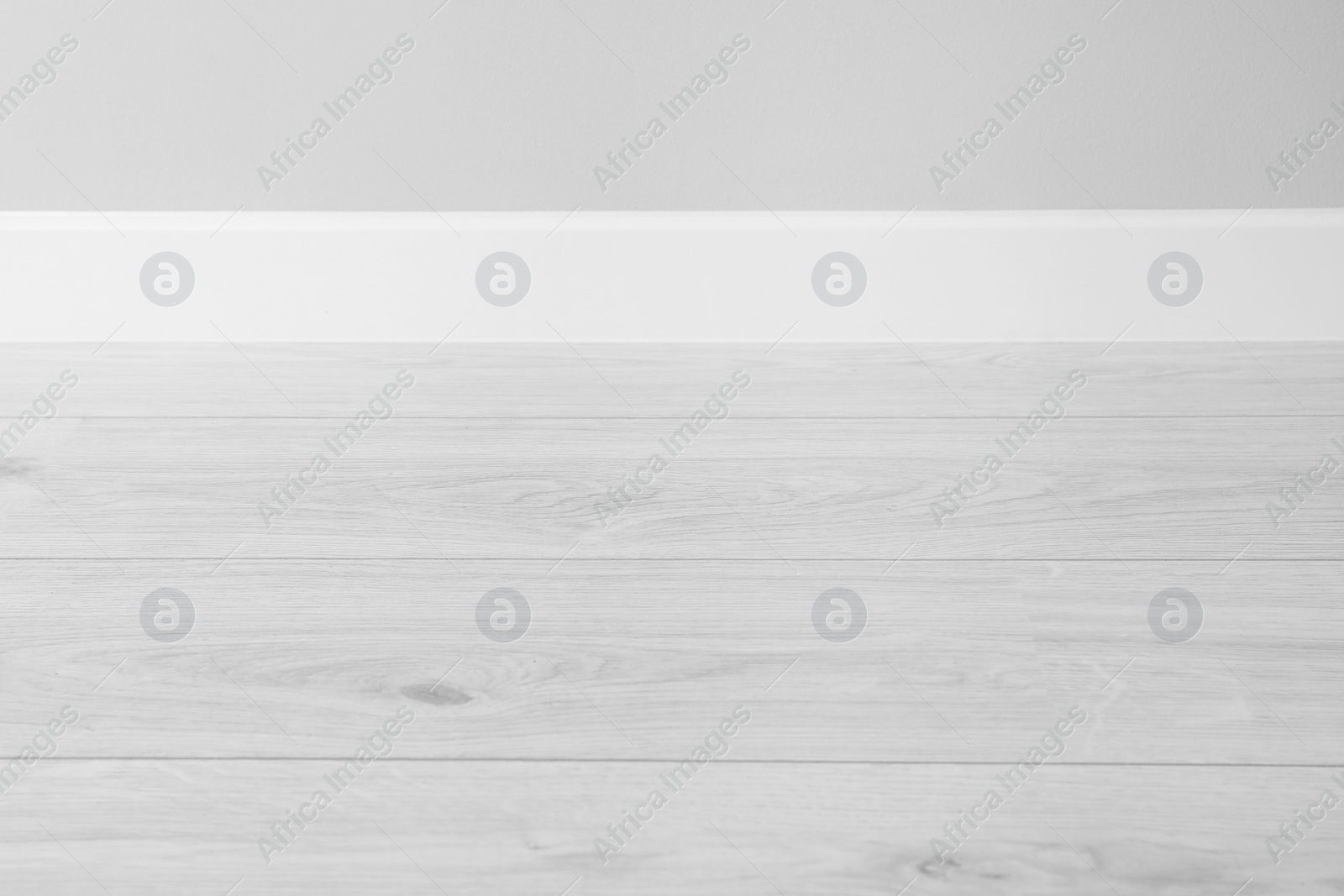 Photo of White plinth on laminated floor near wall indoors