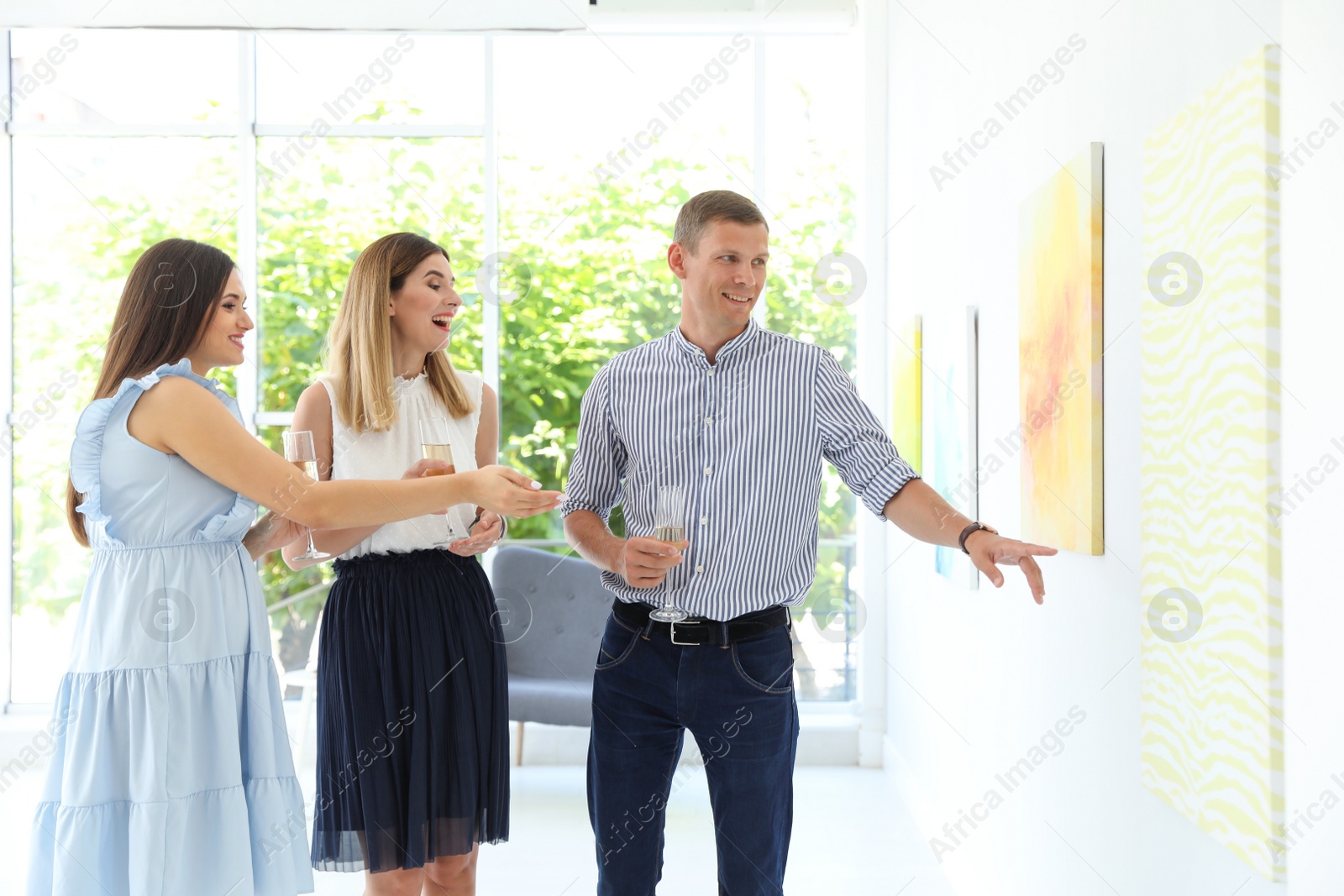 Photo of Group of people with glasses of champagne at exhibition in art gallery