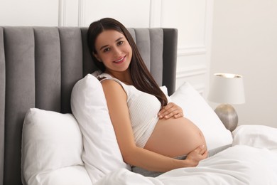 Photo of Beautiful pregnant woman in bed at home