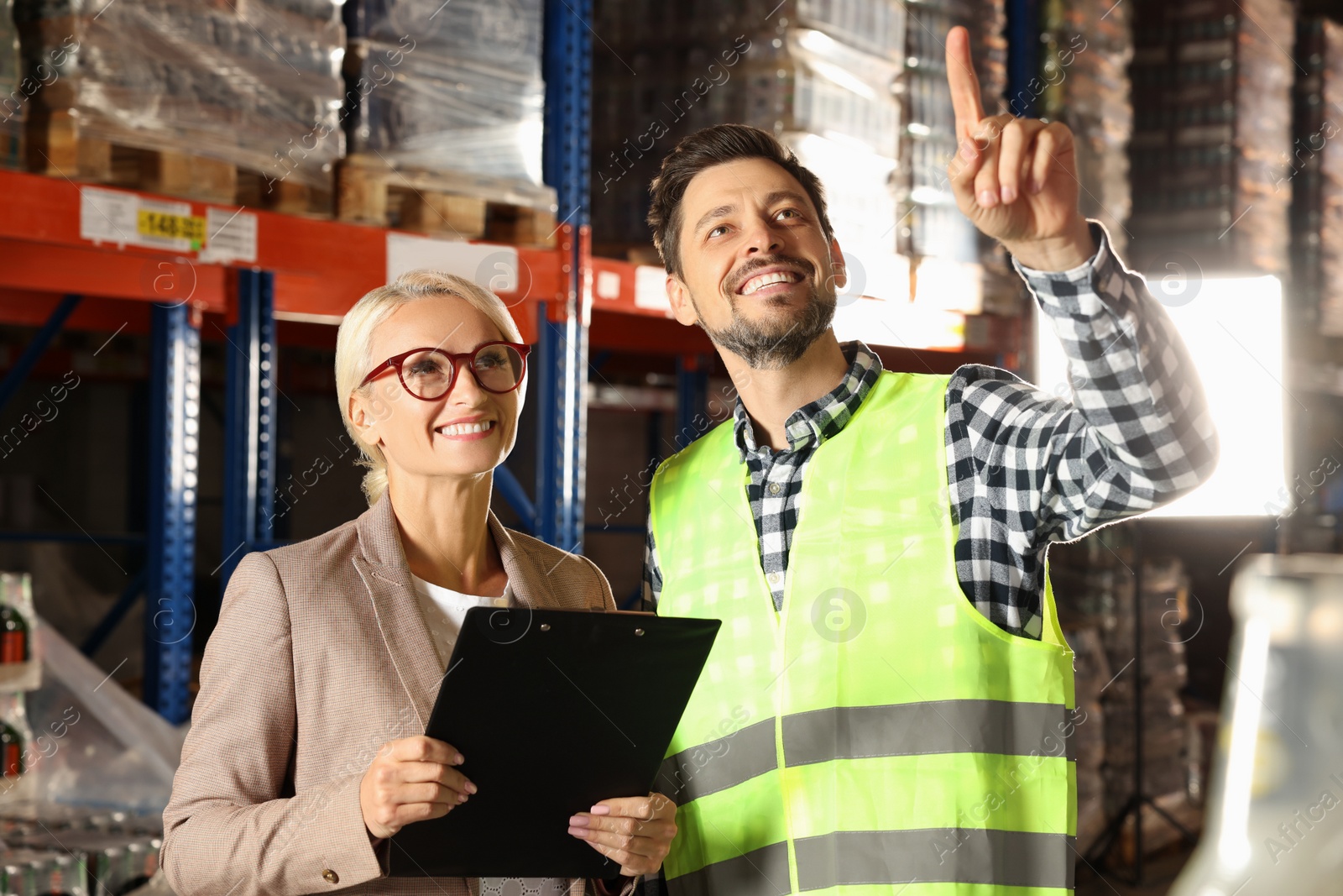 Photo of Manager and worker in warehouse with lots of products