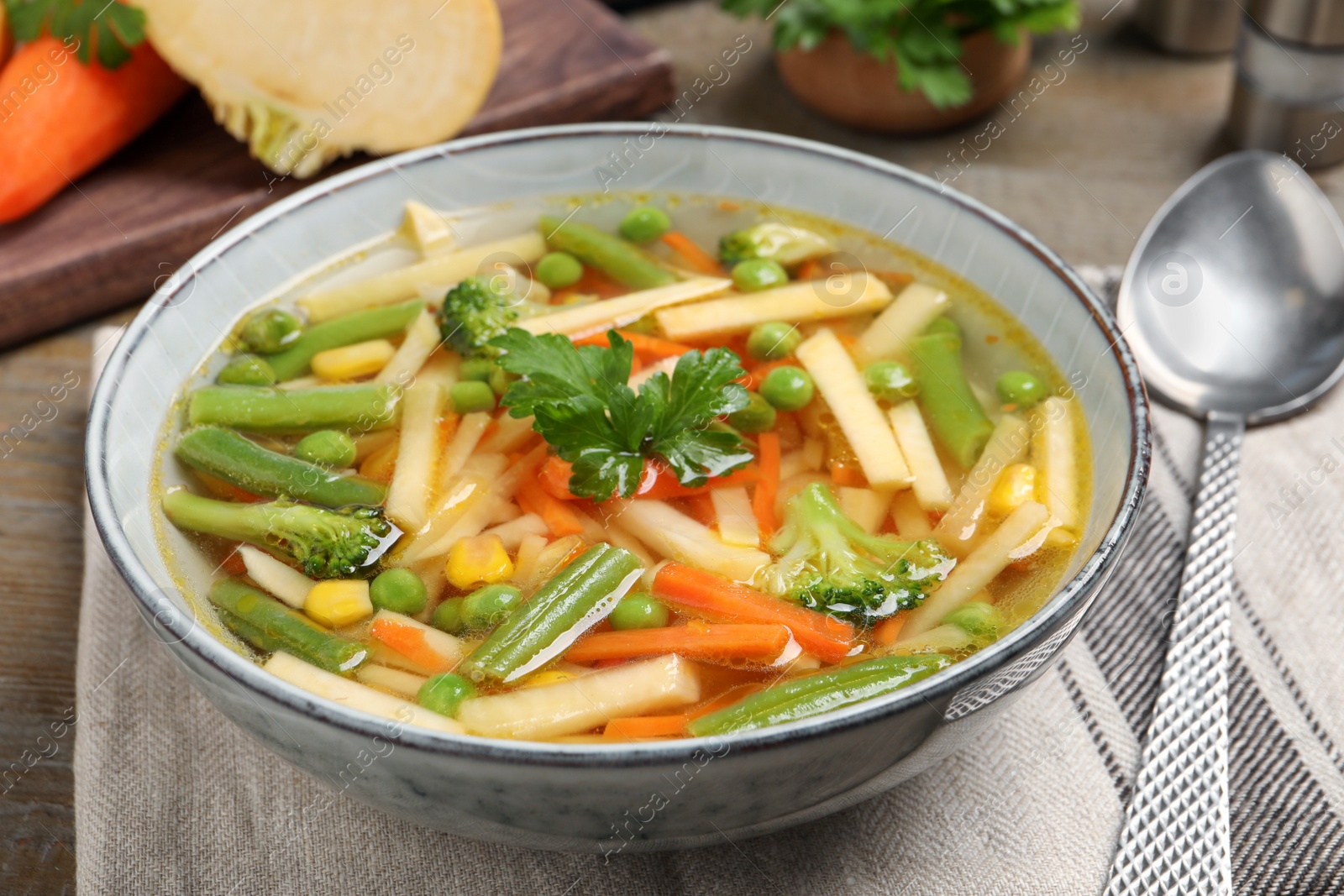 Photo of Bowl of delicious turnip soup on wooden table, closeup