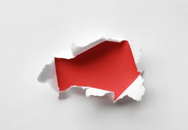 Photo of Hole in white paper on red background