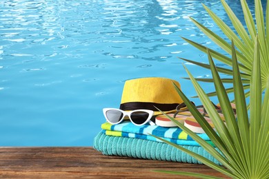 Image of Different beach objects on wooden surface near swimming pool