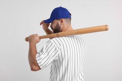 Photo of Man in stylish blue baseball cap holding bat on white background