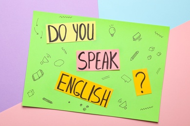 Photo of Note with question Do You Speak English on color background, top view