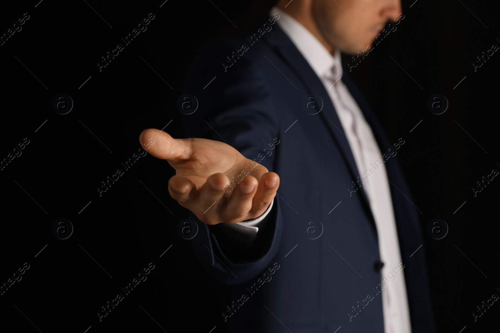 Photo of Man holding something on black background, closeup