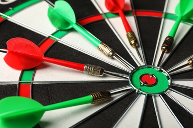 Photo of Red and green arrows on dart board, closeup