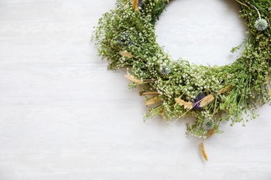 Photo of Beautiful wreath made of wildflowers on white table, top view. Space for text