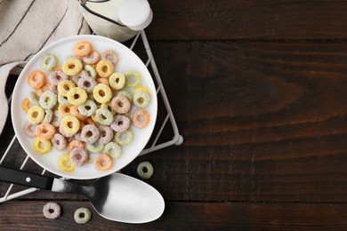 Photo of Cereal rings and milk in bowl on wooden table, top view. Space for text