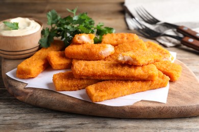 Photo of Tasty fresh fish fingers served on wooden table
