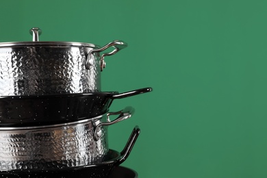 Photo of Stack of clean cookware on color background. Space for text