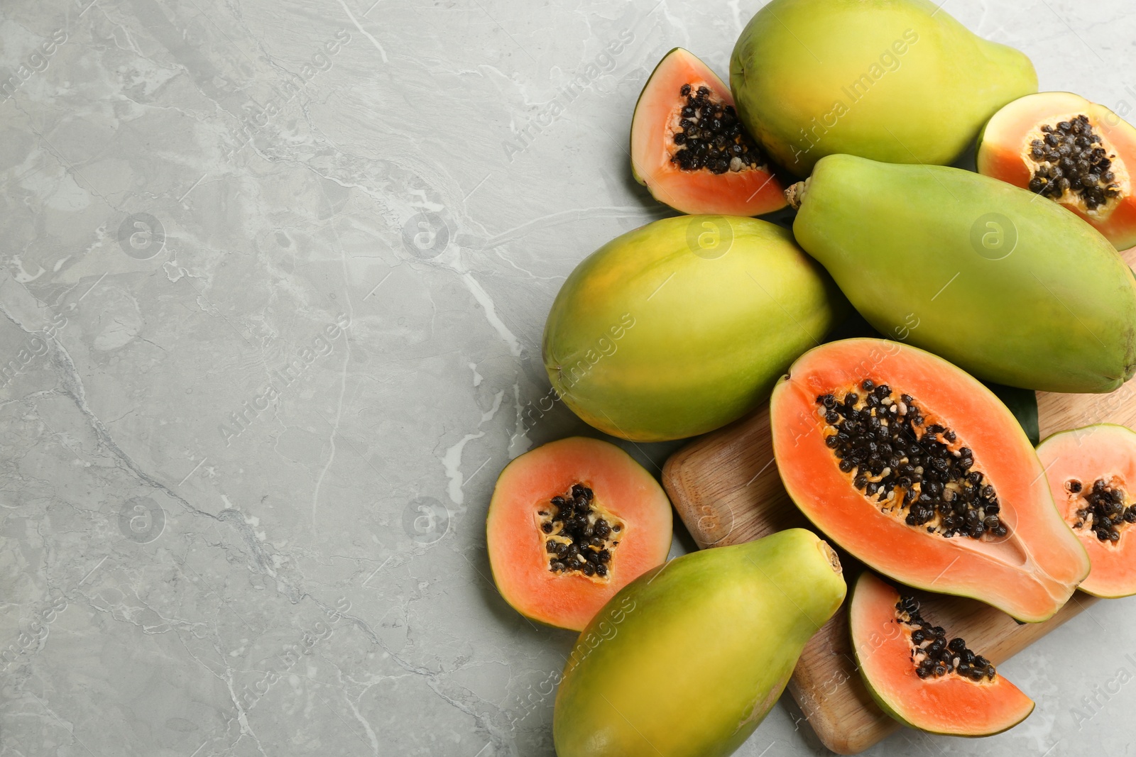Photo of Fresh ripe papaya fruits on light grey table, flat lay. Space for text