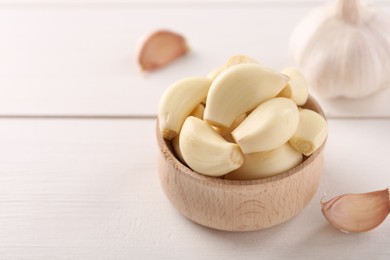 Photo of Fresh garlic on white wooden table, closeup. Space for text