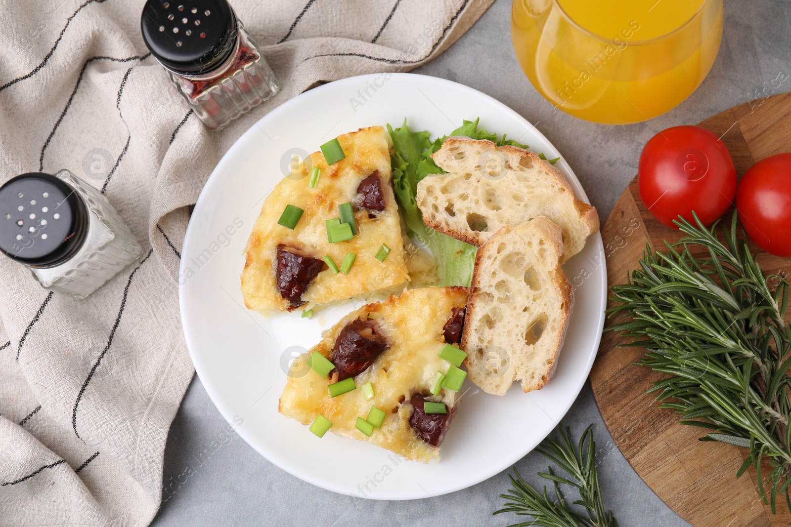 Photo of Tasty sausage casserole served on grey table, flat lay