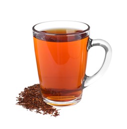 Aromatic rooibos tea in glass cup and scattered dry leaves on white background