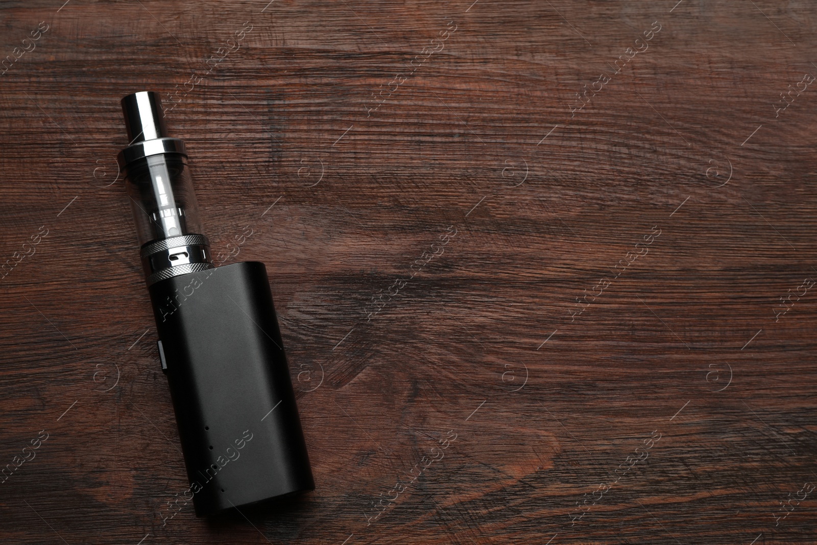 Photo of Electronic cigarette on wooden table, top view with space for text. Smoking alternative